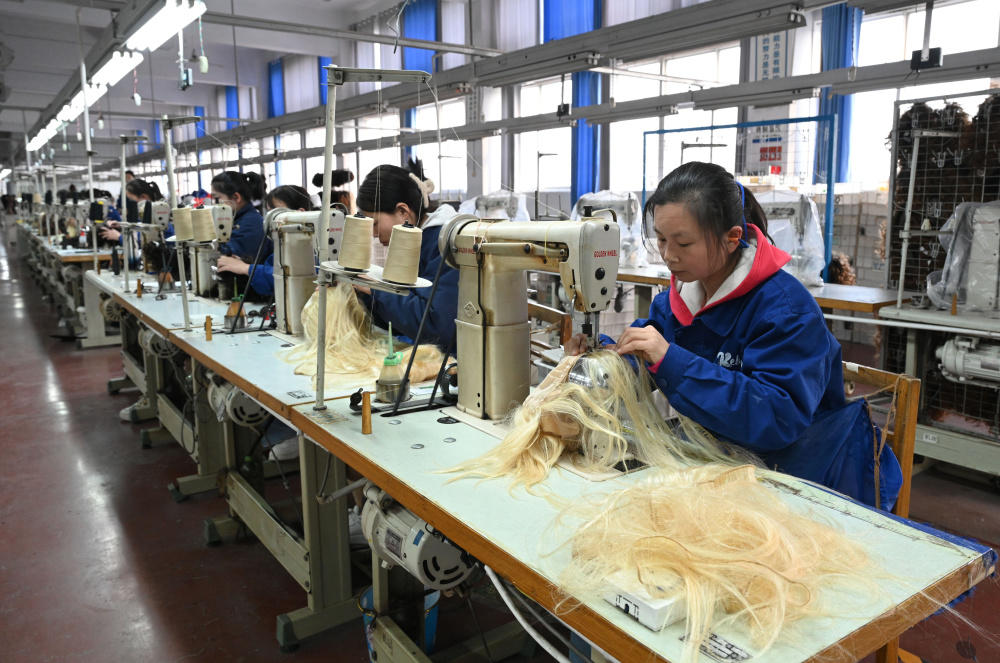 工作人员在河南瑞贝卡发制品股份有限公司的生产车间里制作假发