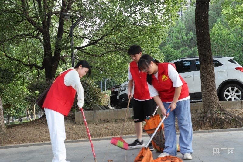 大学生志愿者帮助环卫工人打扫街道(央广网发  刘可  摄)接到热气腾腾