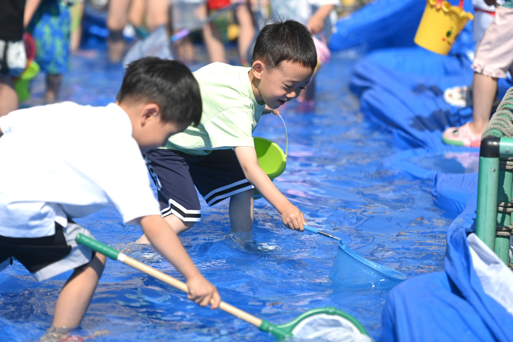 5月29日,杭州市锦绣幼儿园的小朋友参加小网捞鱼活动