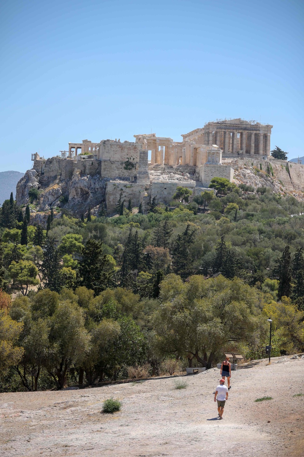 新华社/法新7月17日,在希腊雅典卫城考古遗址入口处,游客与工作人员