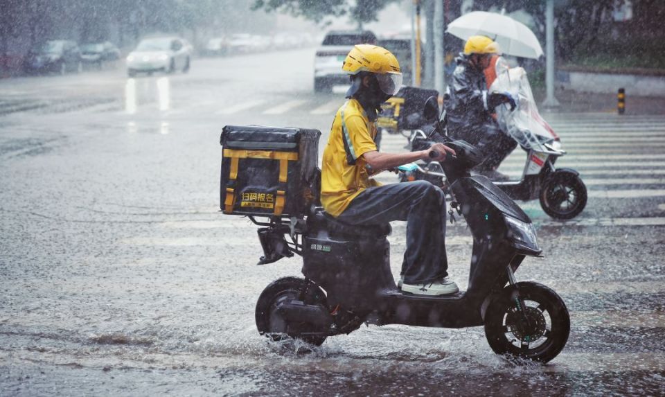 2024年7月24日,北京,外卖骑手在雨中送餐 图/视觉中国