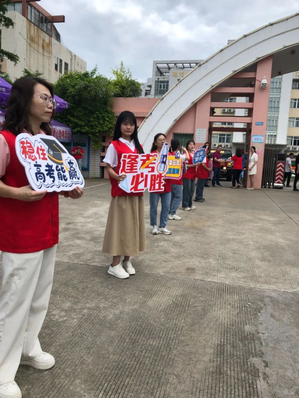 汕头华侨中学:身着红衣的带考老师在候考考生手臂上贴上"高考必胜"小