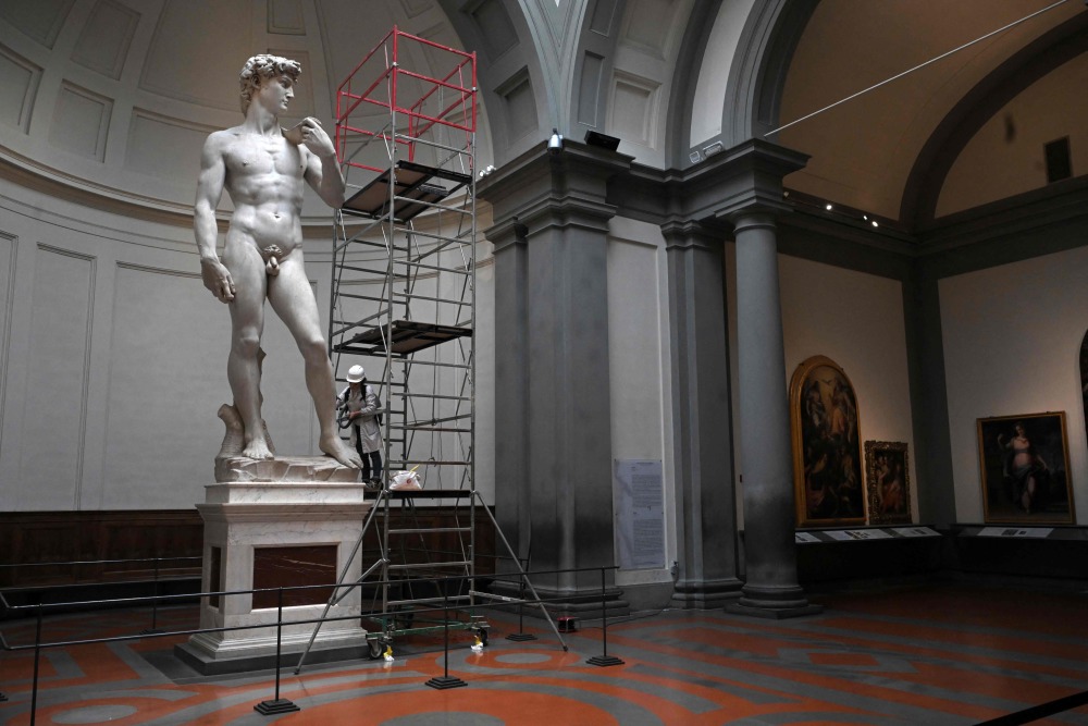 2月19日,在意大利佛罗伦萨美术学院,一名修复技师对雕塑作品《大卫》