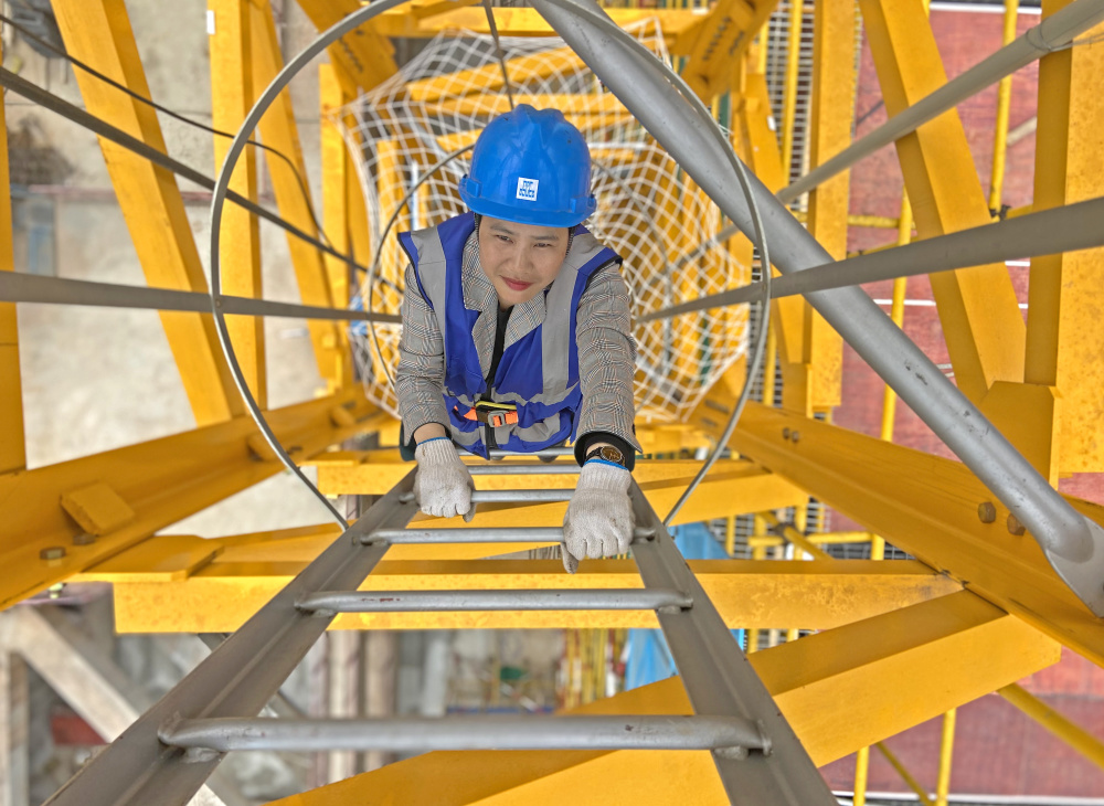 五象大道中建三局一公司南宁中银金融中心项目建设工地,覃桂英爬梯子