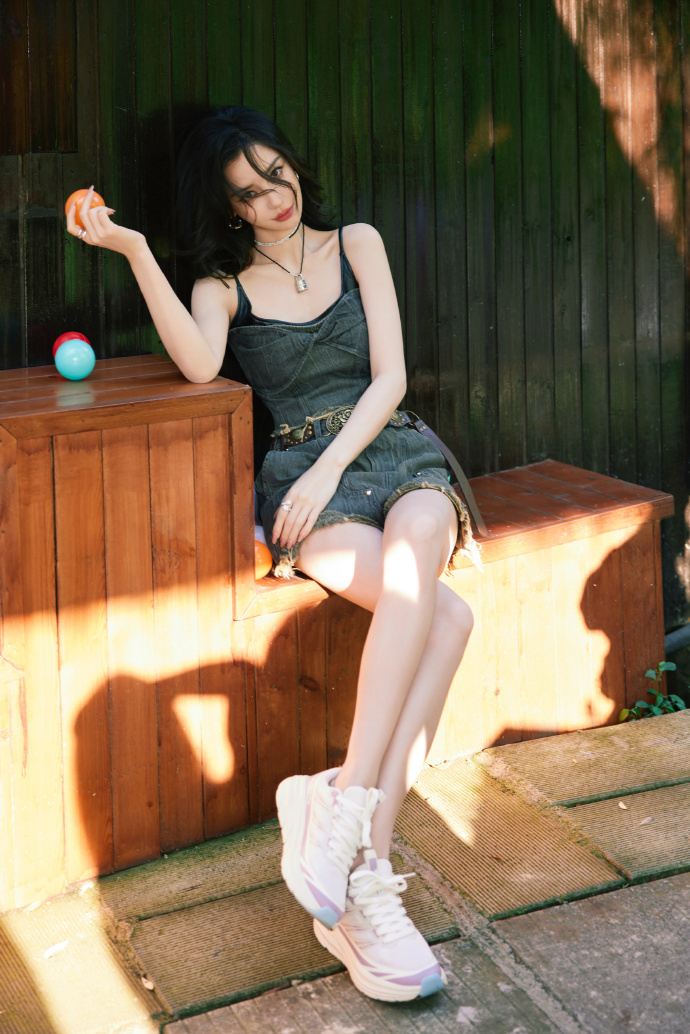 画面中的angelababy也穿着抹胸牛仔上衣,内搭黑色的吊带装,再配上一条