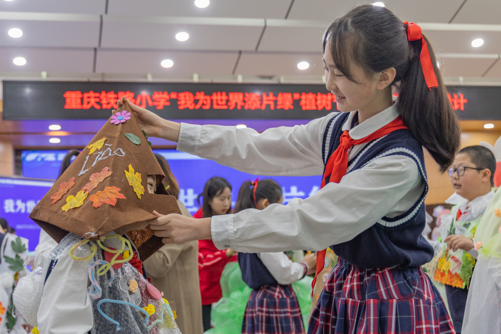 3月10日,重慶市九龍坡區鐵路小學的一名學生在同學的幫助下穿戴自己