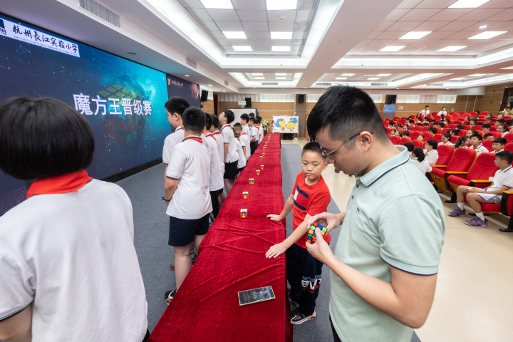 决赛开始前,杭州市魔91协会副秘书97陈霖打乱选手的魔方.