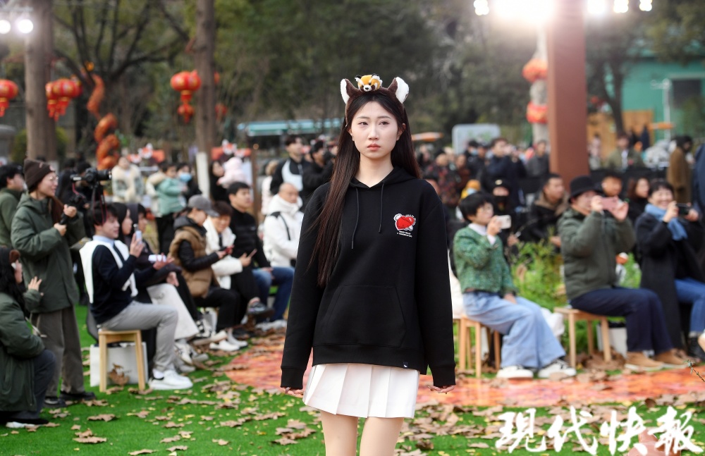 以绿植布置秀场,以落叶为t台,当身着小熊猫元素服饰的模特一一走过时