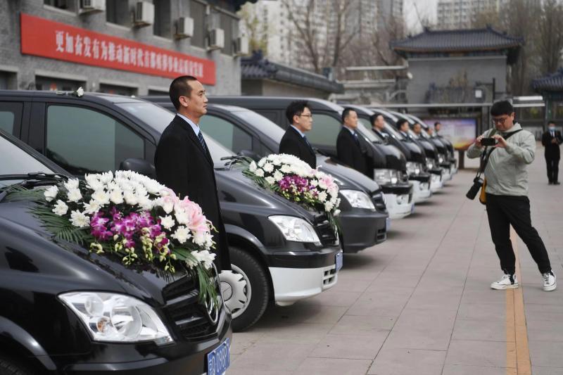 在东郊殡仪馆西侧,数辆殡仪车一字排开,车队司机着装整齐.