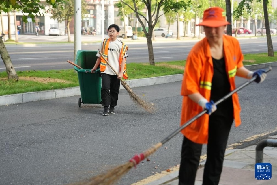 "我帮妈妈扫大街"——小手握扫帚 温情暖街头