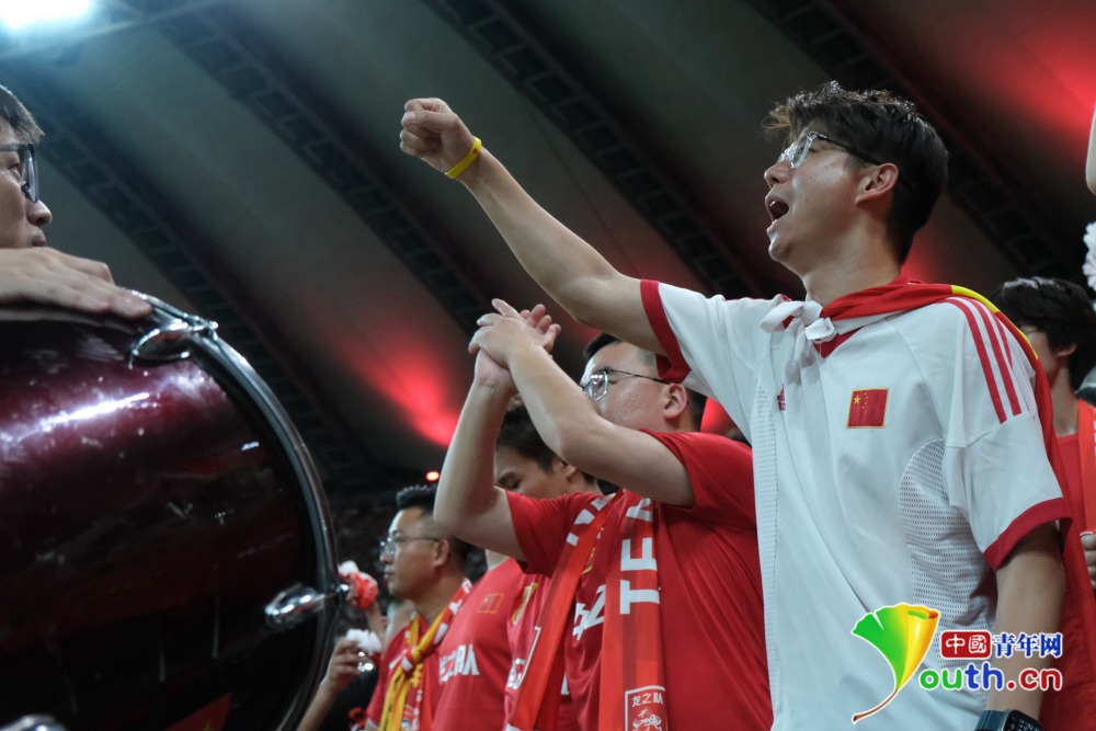 图为一位身披国旗的球迷在看台为国足加油杨逸凡/摄(来源:中国青年网)