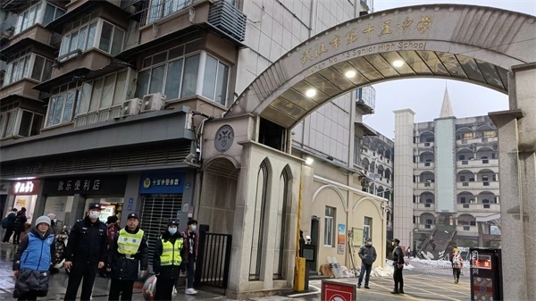 社区工作者与交警在武昌区傅家坡小学,武汉市第十五中学附近疏导家长