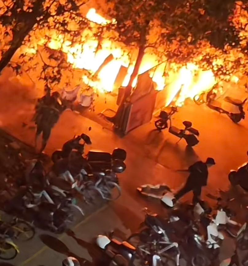 着火区域旁边有学生跑步离开宿舍楼并伴有红色火光视频画面显示现场