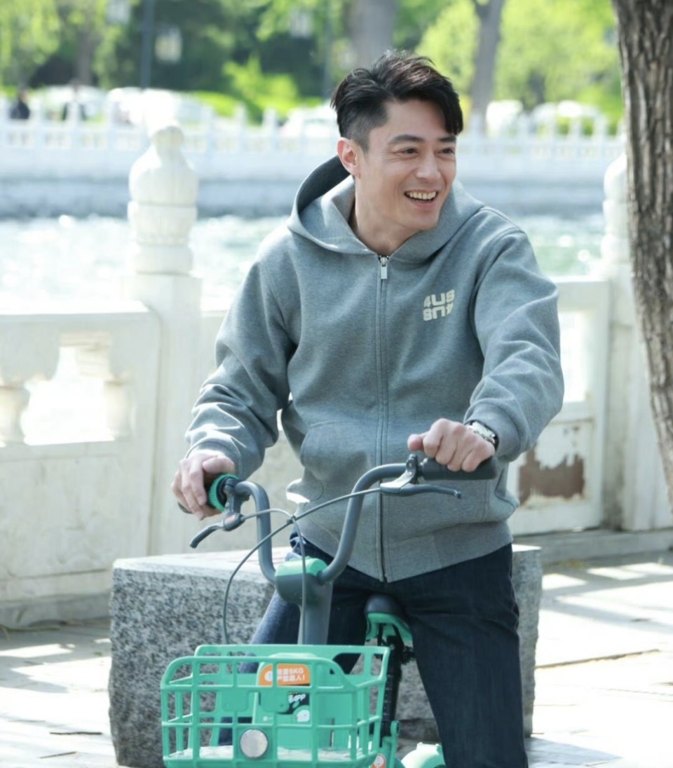 霍建华穿了一件带帽卫衣搭配牛仔裤,脚上穿着一双皮鞋,打扮年轻又时尚