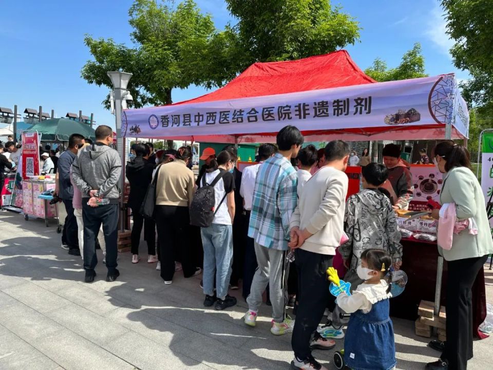 在展台上,主管中药师何雪梅一边向游客分发解暑清凉的酸梅汤和医院