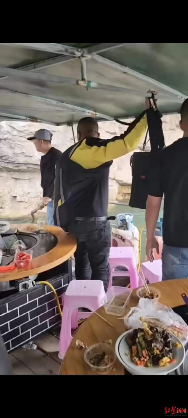 岸边黄色岩石上大批游客在拍照游玩,有游客站在高处拍摄桃林口水库