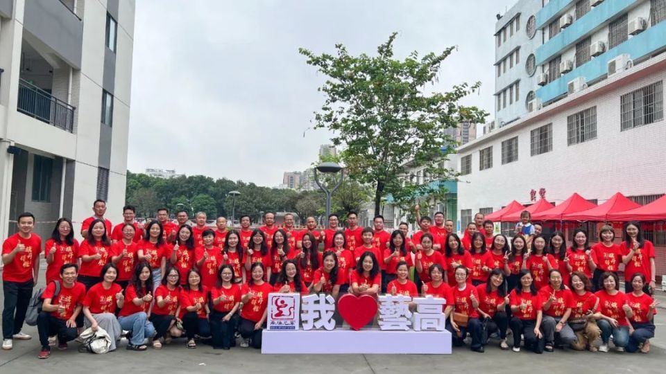 石门高级中学各科老师身着红色上衣,手拿向日葵,祝愿同学们高考必胜