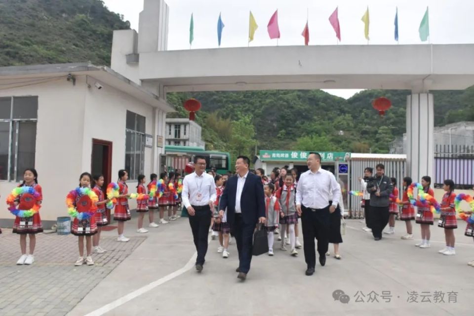 靖西市武平镇武平中心小学门口,武平镇武平中心小学校长马日克带领