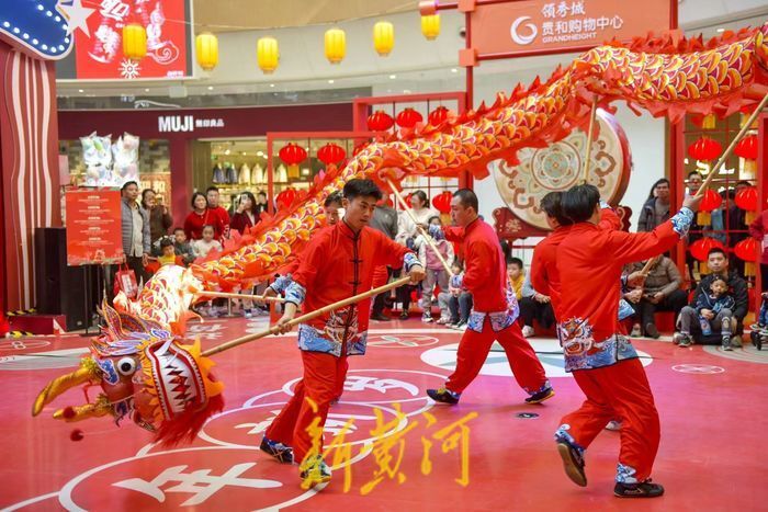 舞龙队员在舞台上展现蛟龙周游,头尾齐钻,龙摆尾和蛇蜕皮等动作,同时