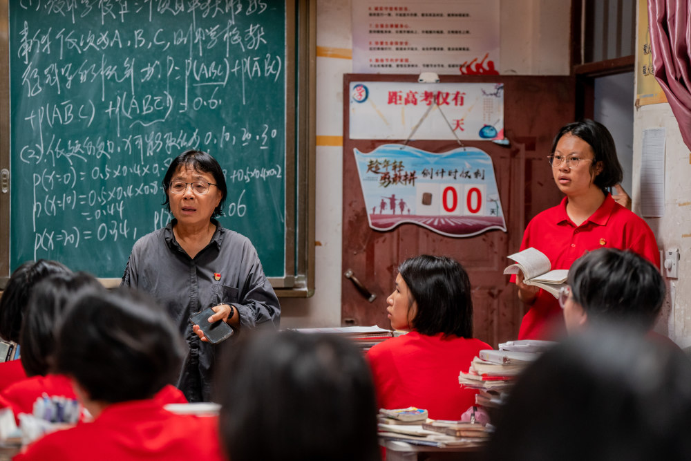 6月7日,张桂梅组织走出考场的学生准备返回学校.