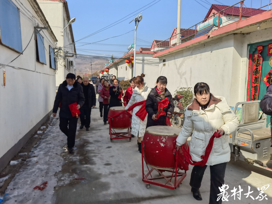 敲锣打鼓,给"好媳妇"的娘家送喜报.