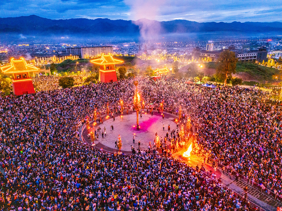 云南大理巍山万人载歌载舞欢度火把节,矗立3吨重巨型火把