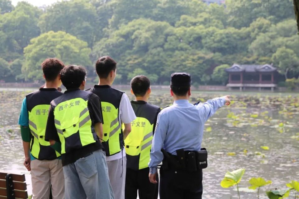 民警带领"生态西子义警"正在关注湖边"爱心桥"搭建情况,方便小鸳鸯