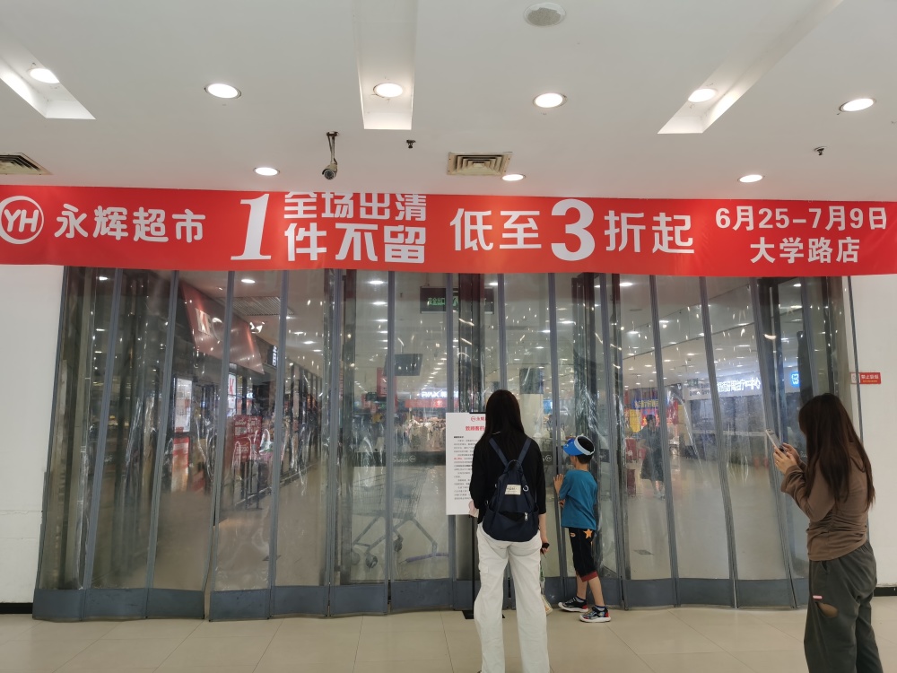 全场出清,一件不留,低至3折起"等促销标语字样的红色横幅,横幅正下方