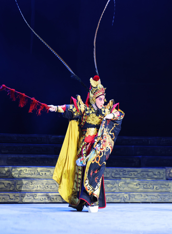 手持红色马鞭,在音乐和锣鼓中,蹉步,翻身,趟海,跳叉,在高亢激昂的京剧