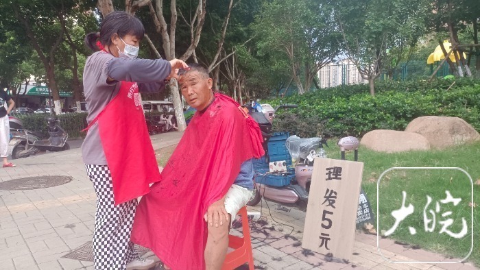 13高温下的露天工作者:街头理发师免费为家庭困难顾客理发