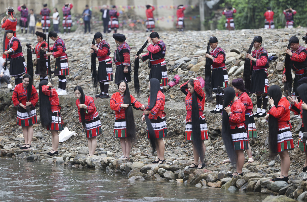新华社记者 胡星宇 摄4月22日,一名瑶族妇女在河边梳洗长发.