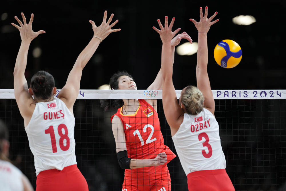 8月6日,中国队队员李盈莹(中)在比赛中扣球.新华社记者 鞠焕宗 摄