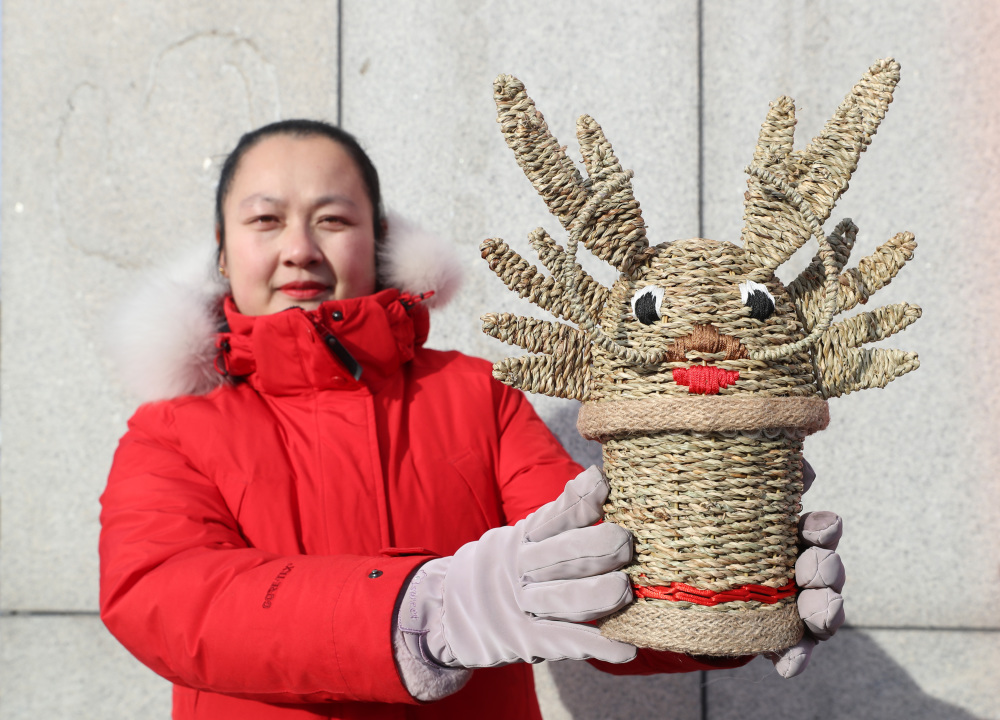 2月1日,在盘锦小亮沟苇艺草编专业合作社,农民展示编织的芦苇工艺品.