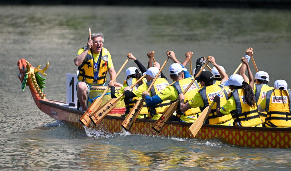 6月22日,在天津海河龙舟赛上,西班牙籍龙舟鼓手(左)在比赛中指挥引导