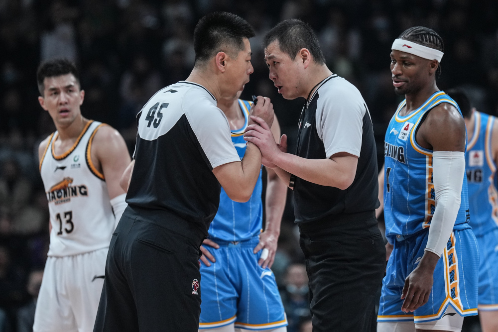 4月18日,主裁判李成新(前左)在比赛中与第二副裁判袁宁鹏沟通.