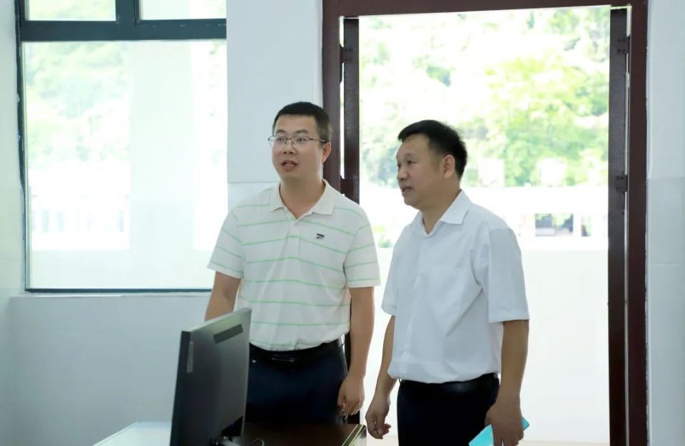 马永强与凌云县第二中学校长张浩共同为教师电子备课室揭牌.