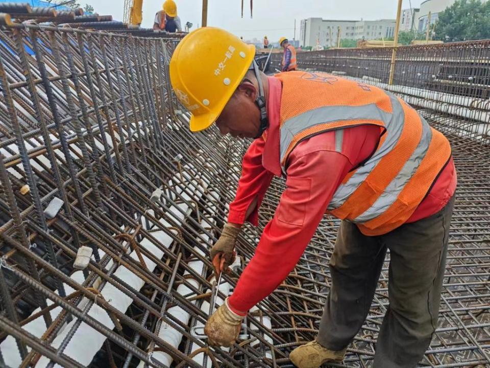 柳悦桥项目施工现场,范俊华正在绑扎钢筋
