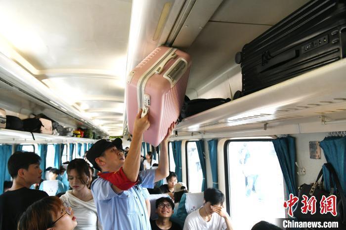 图为王利君在t290次列车上为旅客摆放行旅.