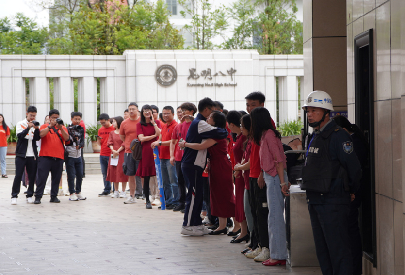 在昆明市第一中学西山学校门口,陈女士穿着红色旗袍,目送孩子走入考场