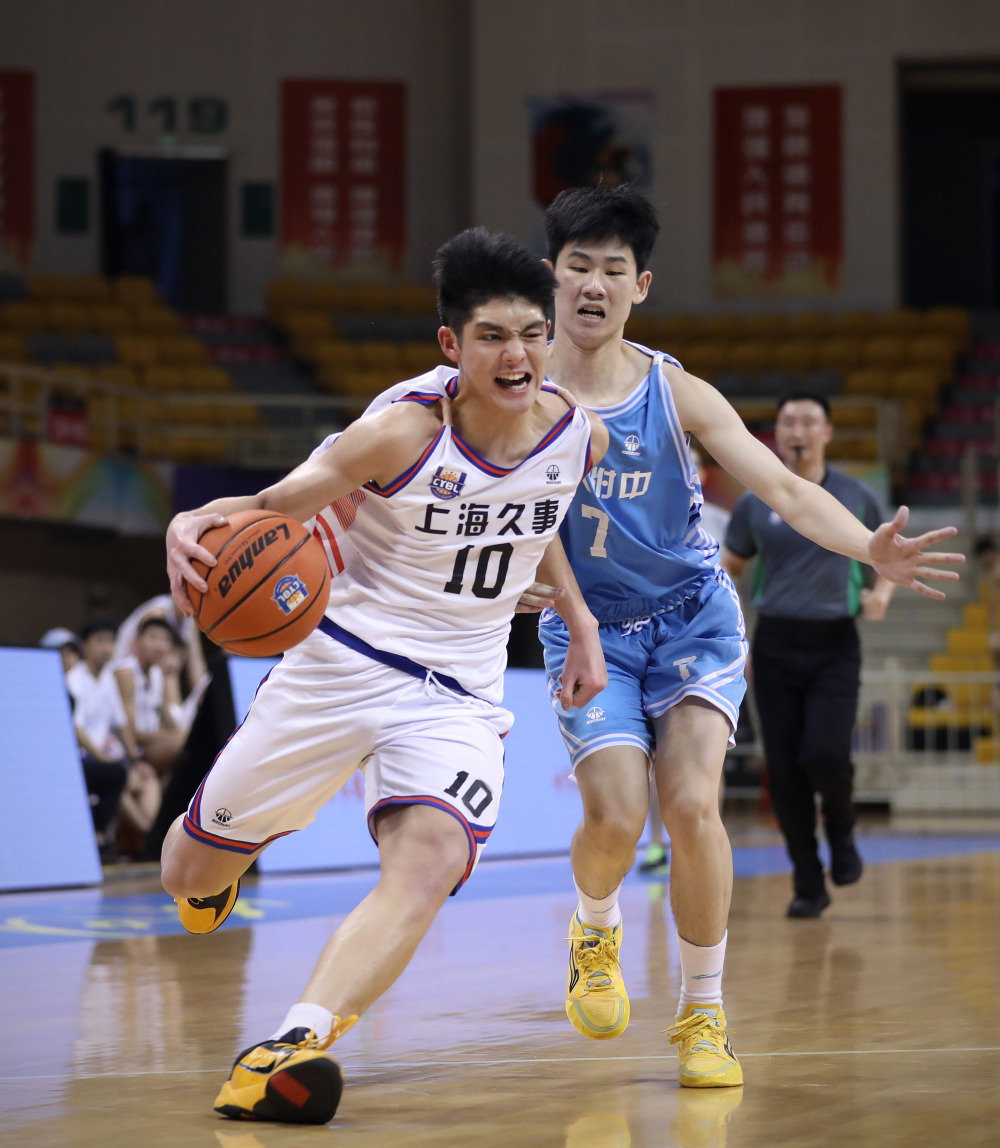 6月30日,上海久事队球员王子恒(左)在比赛中带球突破.