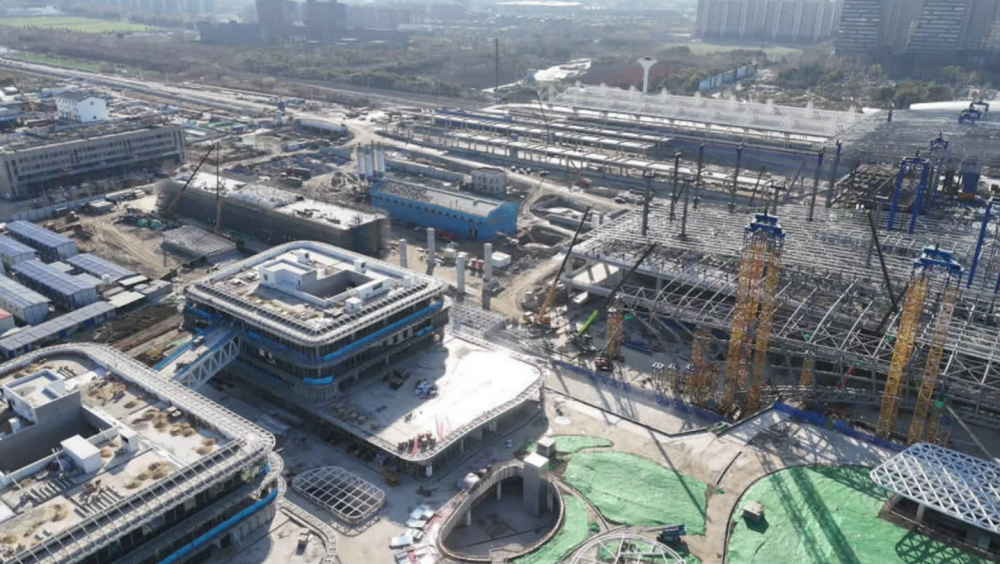 元旦假期万家团聚欢庆新年之际南通火车站综合客运枢纽开发工程的施工现场一派热火朝天的繁忙景象超过300名建设者放弃休息坚守在施工一线以“开局即冲刺”的奋斗姿态全力打响“工期保卫战”今天上午项目现场机器轰鸣施工人员在各自岗位上紧张有序地作业四栋配套楼栋的外立面玻璃正在同步安装防水铝板的安装工作也在同步推进目前该项目已累计完成总工程量的80%以上南通建交建筑工程有限公司施工现场负责人侯旭东介绍：“项目所