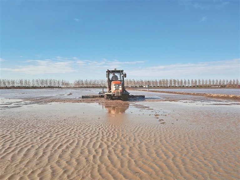 服务中心水田地进行精准平地作业,机车行驶过后土地顷刻间变得平整