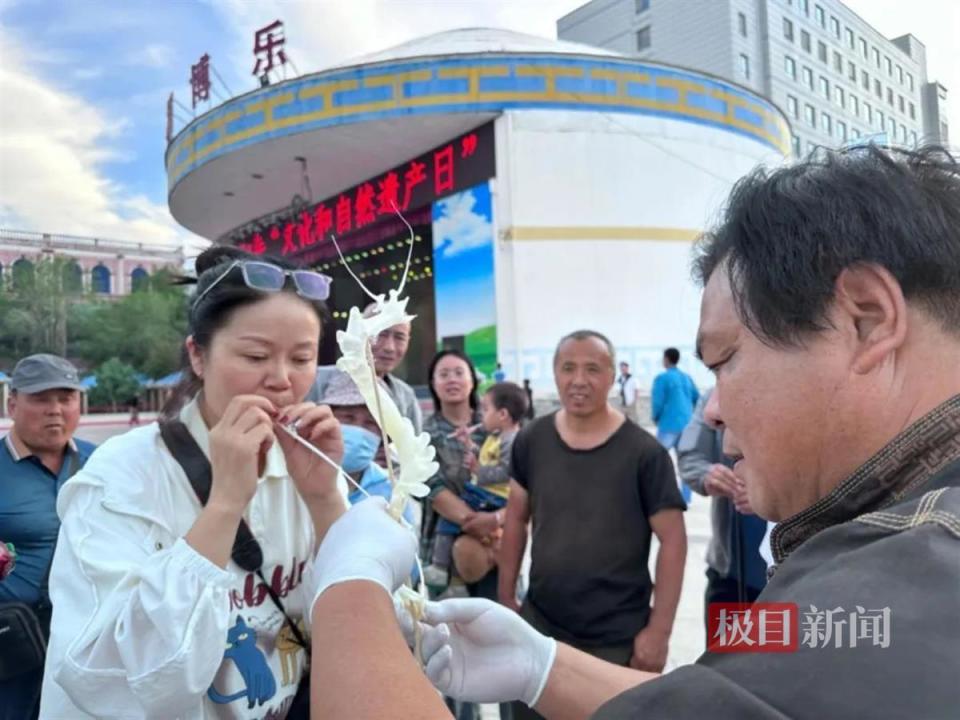 在人气最旺的天门糖塑展位,市民排队体验吹糖人的乐