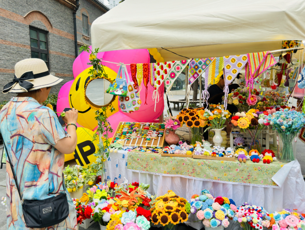 "手工鲜花摊位前,不少白领被五颜六色的手工针织花所吸引.