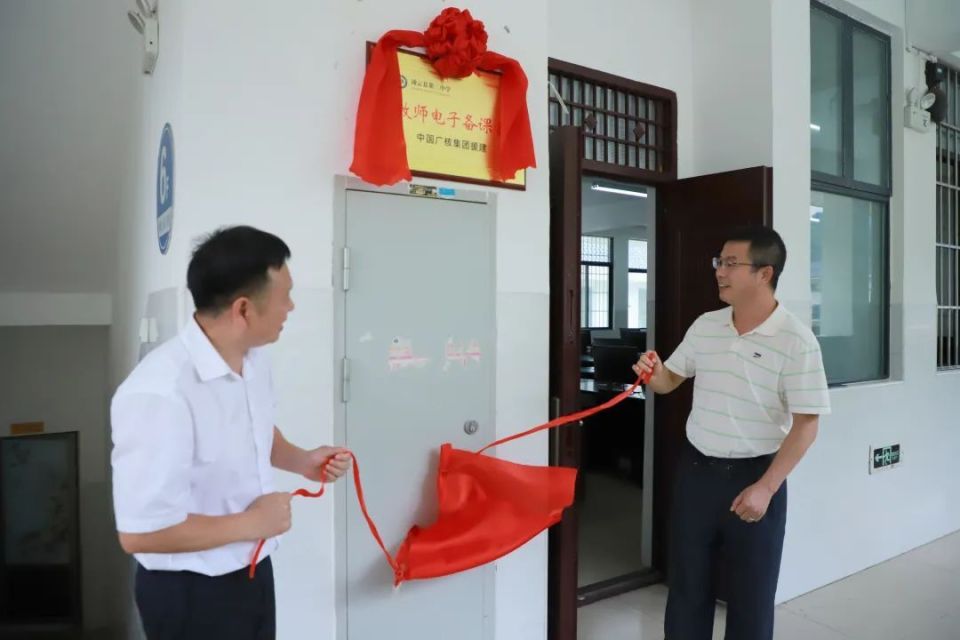 马永强与凌云县第二中学校长张浩共同为教师电子备课室揭牌.