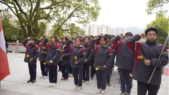 资溪一中团委负责人周芸带领全体教师在烈士纪念碑下庄严宣誓:继承