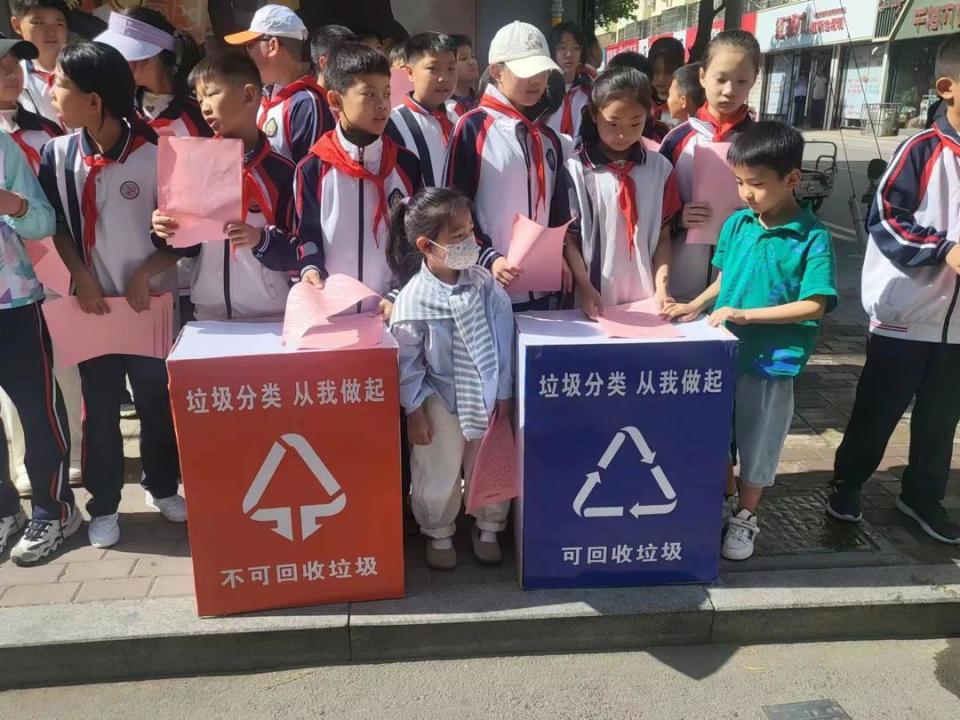 活动现场,学生们耐心向过往的市民解释垃圾分类的重要性和方法.