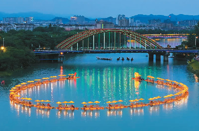由竹筏连成的金色"巨龙"在宁国市西津河上巡游.