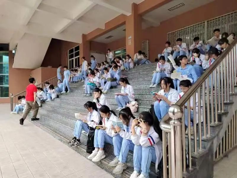 汕头华侨中学:身着红衣的带考老师在候考考生手臂上贴上"高考必胜"小