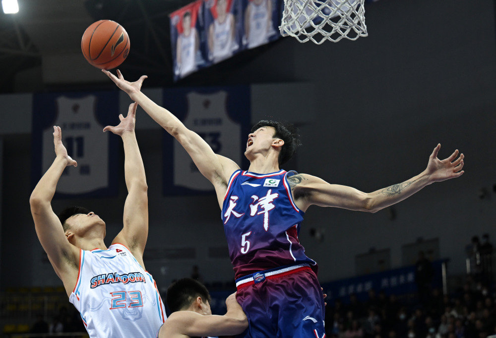 11月10日,天津先行者队球员赖俊豪(右)在比赛中争抢篮板.